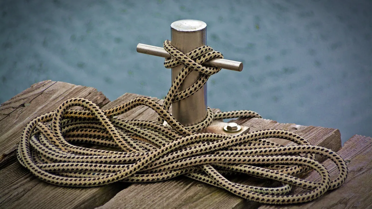 Un cordage lové autour d’un taquet d’amarrage